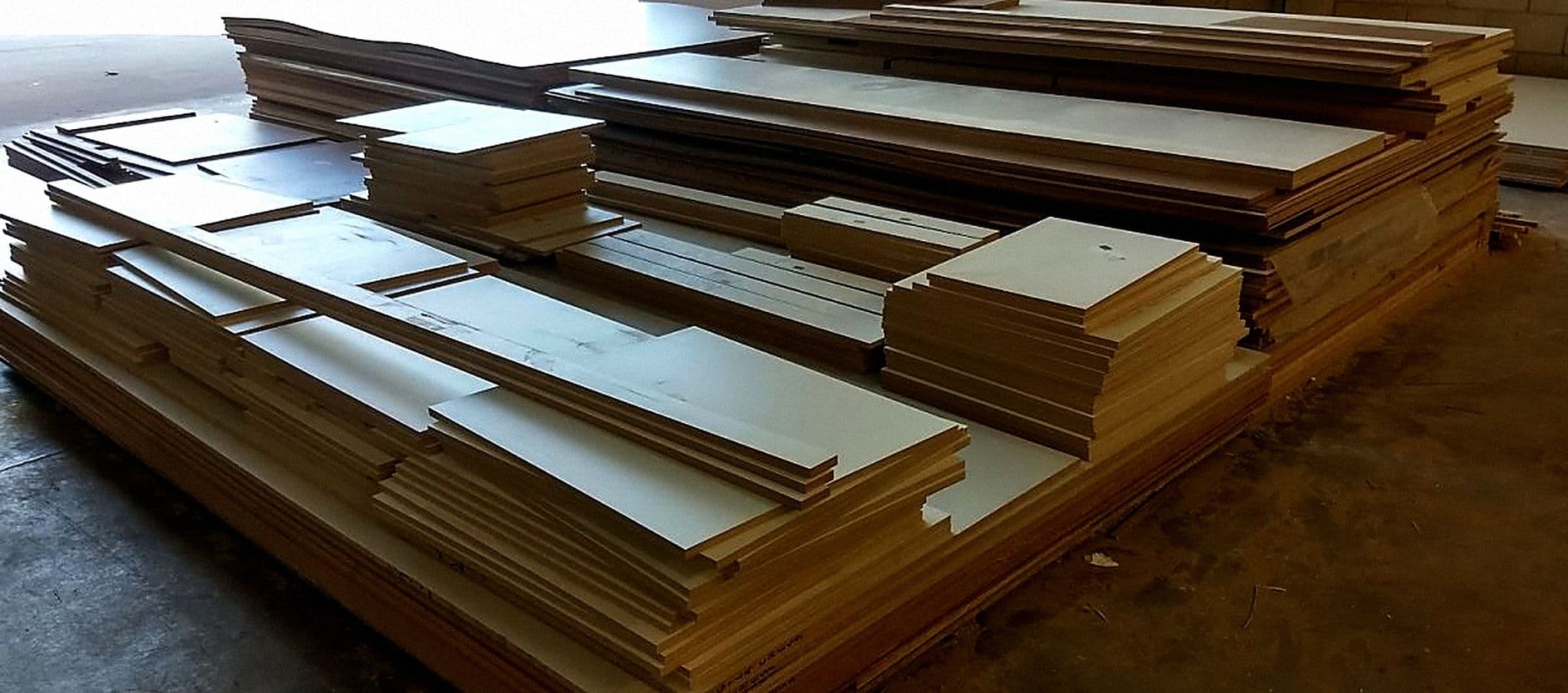 Peças de MDF cortadas e separadas em pilhas na PS do Marceneiro